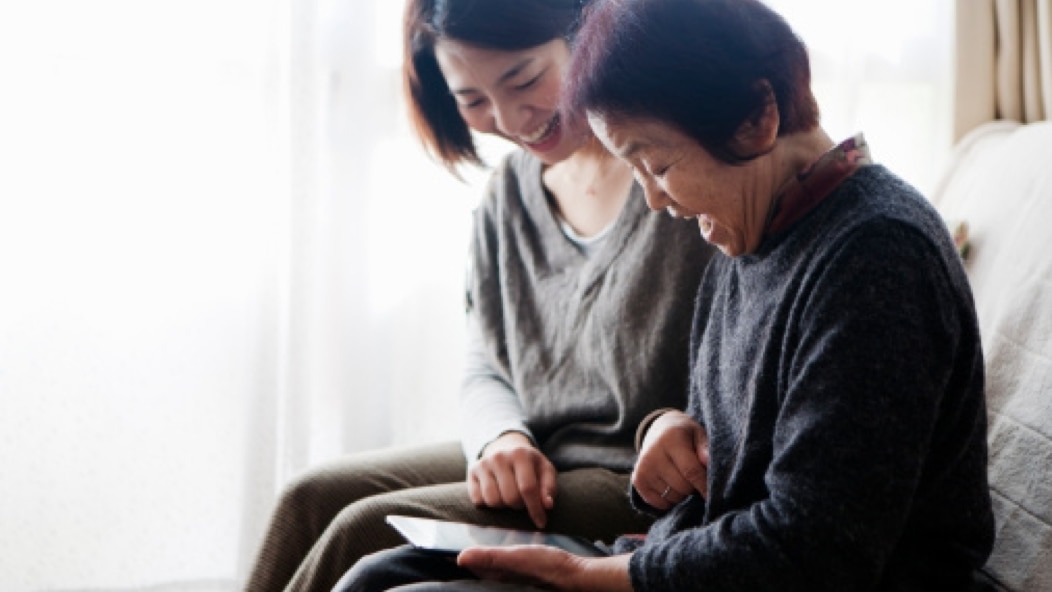 Two people sitting and reviewing a document together.