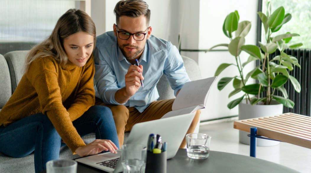 A man and a woman looking at a computer screen symbolizing how Vanguard tailors our financial advice to meet the specific needs of clients.